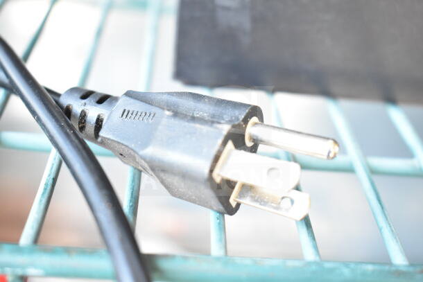 Image of a power plug connected to an HP LaserJet Pro MFP M127fn countertop printer. Close-up on plug details.