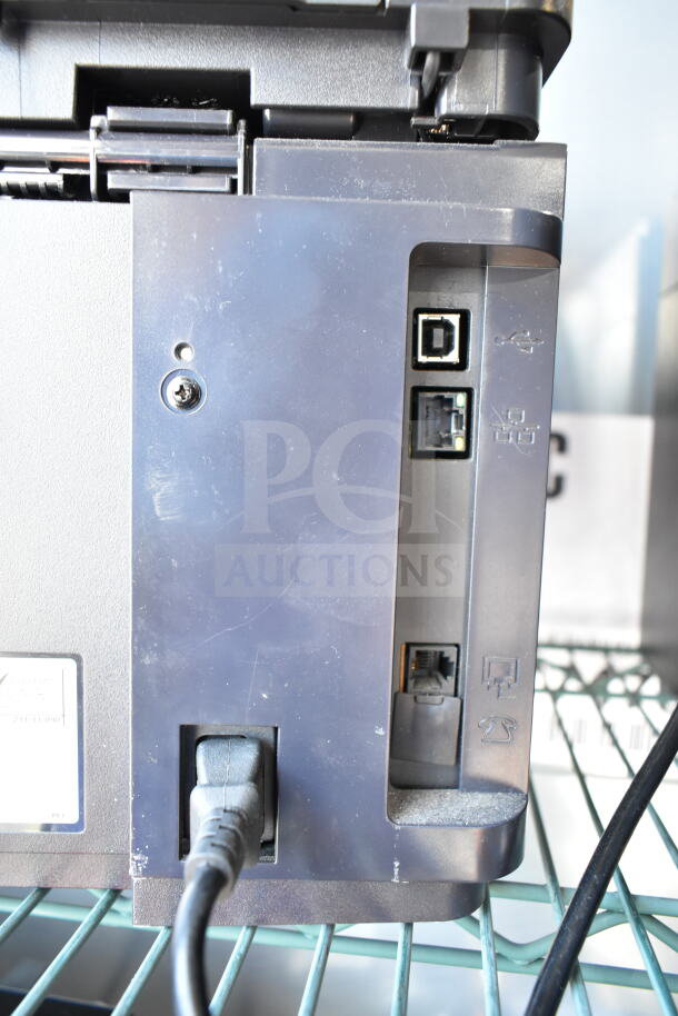 HP LaserJet Pro MFP M127fn printer showing back panel with USB, Ethernet, and power ports on a metal shelf.