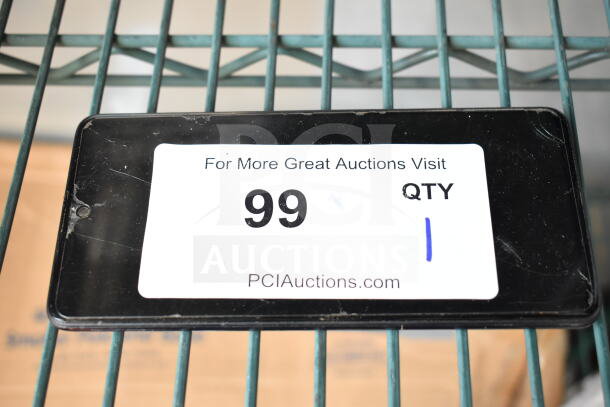 Samsung smartphone with visible screen scratches, auction lot number 99, displayed on metal shelving, PCI Auctions label.