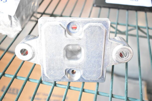 Metal component with holes, industrial purpose, on wire shelf. Possible part of mixed auction lot.