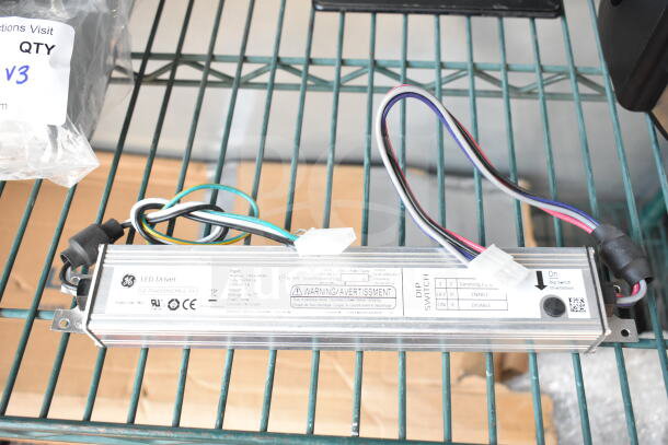 General Electric LED Driver with multiple colored wires, model PS4000NCNMUL-5Y, in used condition on a metal shelf.