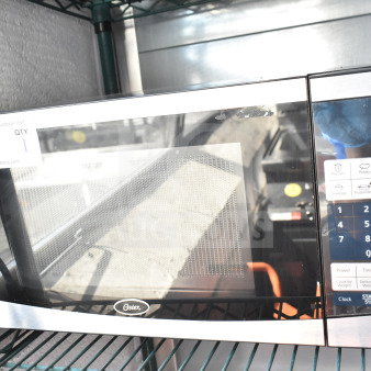 Oster OGYU701 countertop microwave oven, 120 volts, 1 phase, digital controls, silver and black finish, in good condition.