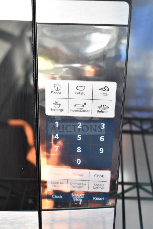 Oster OGYU701 Countertop Microwave Oven with touchpad controls for popcorn, potato, pizza, and more. 120 Volts, 1 Phase.