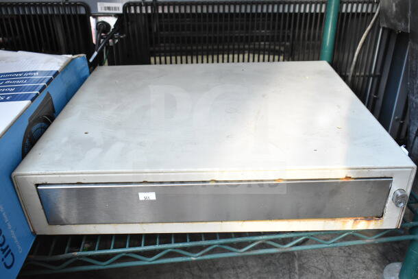 Clover cash drawer, metal with visible wear and rust, labeled "555," on a storage shelf.