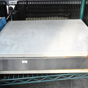 Clover cash drawer, metal with visible wear and rust, labeled "555," on a storage shelf.