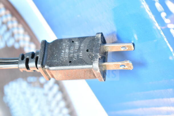 Close-up of a power plug for the Best Comfort Fan, showing a standard two-prong design with visible markings.
