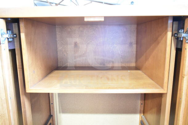 Wood pattern two-door cabinet, open view. Features natural wood finish, metal hinges. In good condition.