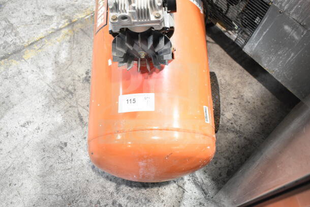 Craftsman air compressor with visible wear, orange tank, and label marked "115 QTY." Features fan and wheels for mobility.