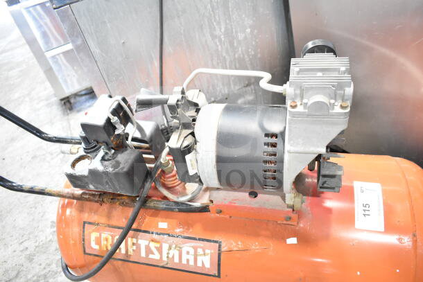 Craftsman air compressor, used condition, visible wear, orange tank, black motor, model label intact.