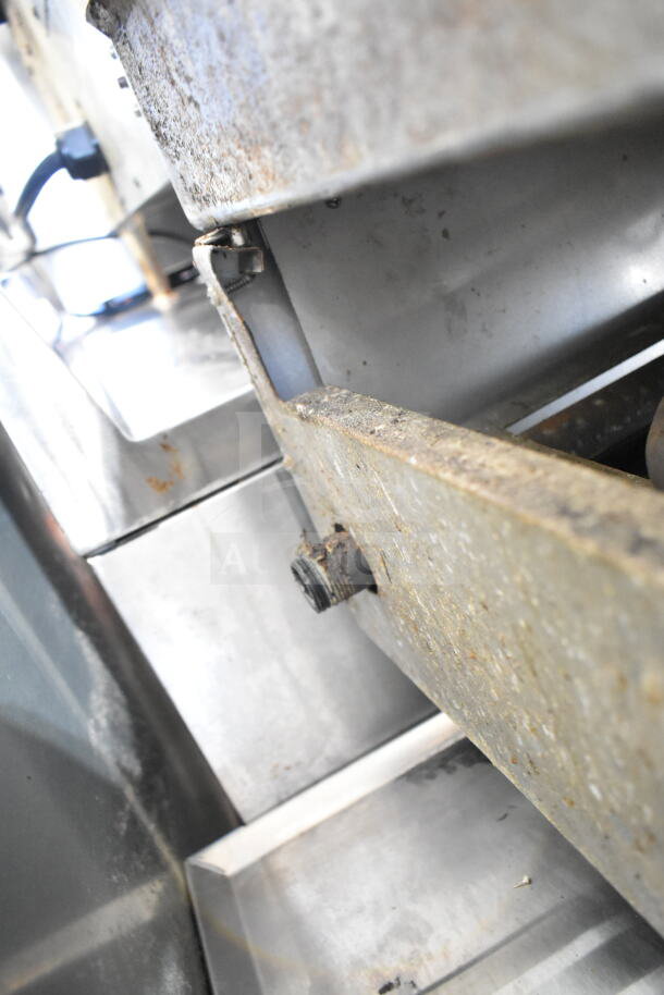 Commercial countertop gas-powered flat top griddle with visible rust and wear, close-up on metal components.