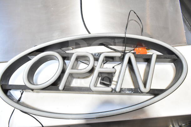 Oval-shaped light-up "Open" sign with visible wiring and plug. In good condition, suitable for storefront display.