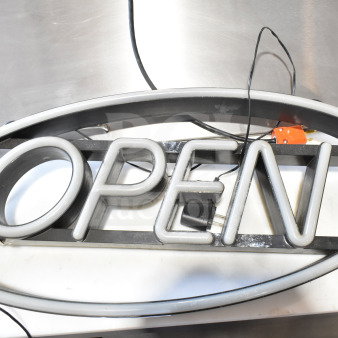 Oval-shaped light-up "Open" sign with visible wiring and plug. In good condition, suitable for storefront display.