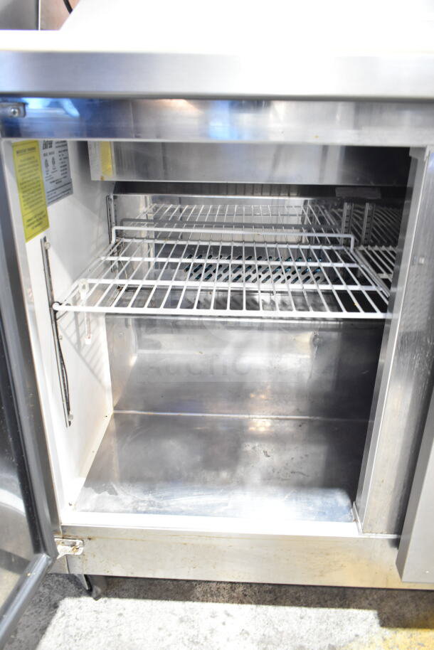 Entree S48-SI-HC commercial prep table interior, stainless steel, shelves, model and caution labels visible.