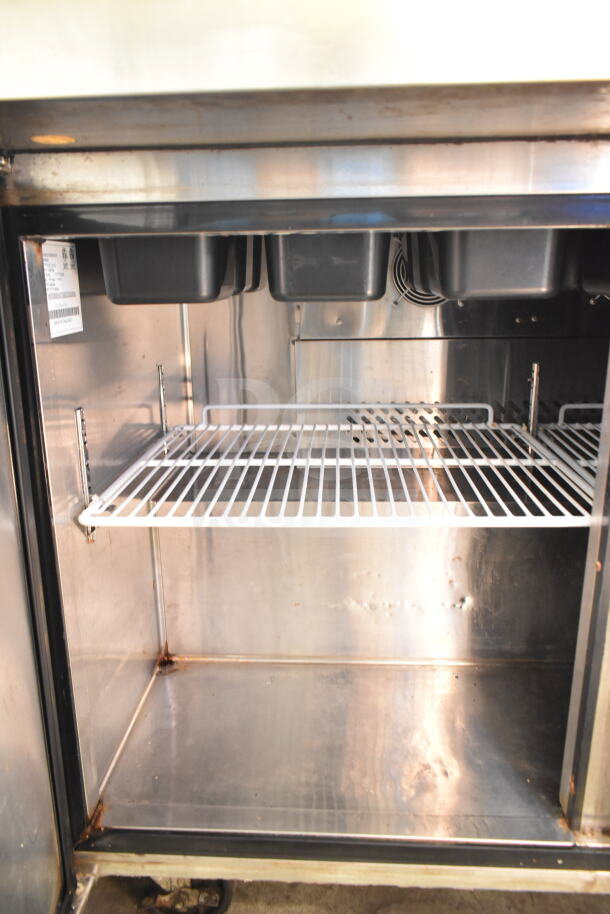 Atosa MSF8308GR sandwich prep table interior, showing wire shelf and black bins; steel finish with visible label.