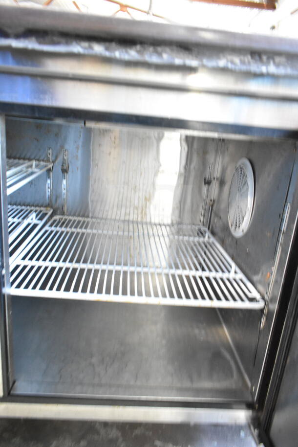 2018 Atosa MPF8202GR commercial pizza prep table interior. Features wire shelving and stainless steel construction.
