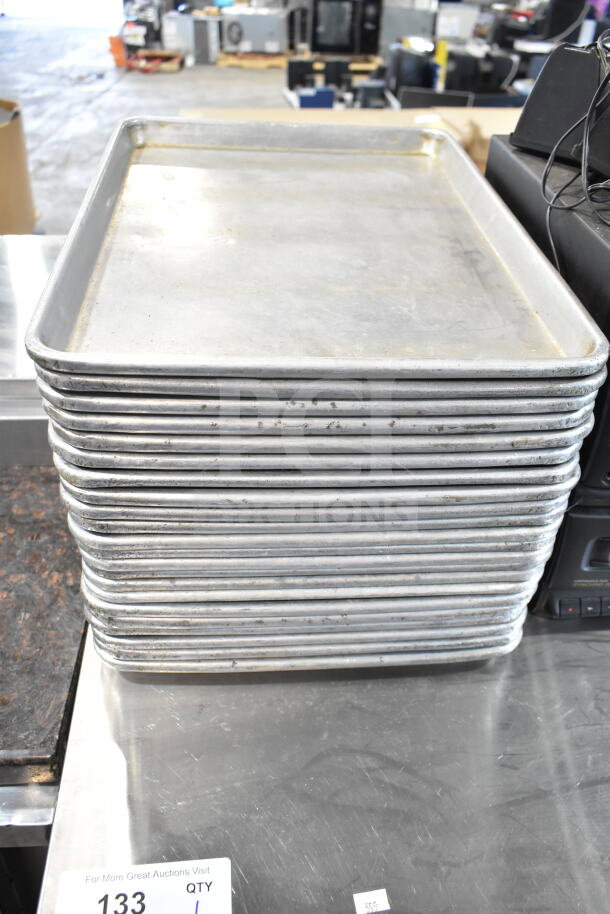Stack of 45 various sized metal baking pans in used condition, auction lot number 133 visible.