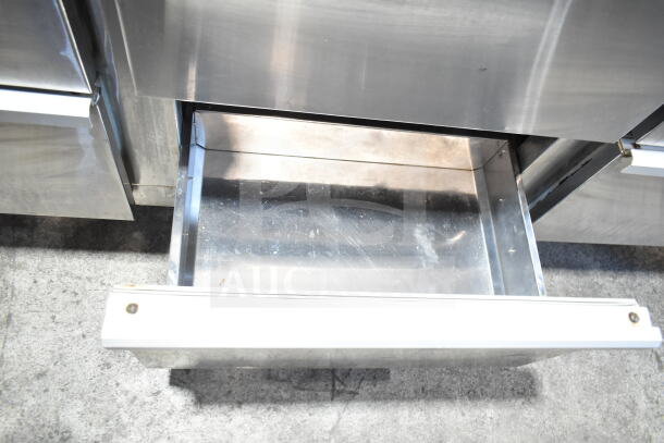 Cooltech commercial pizza prep table with stone cutting board, featuring 6 drawers. Visible open stainless steel drawer, showing interior.