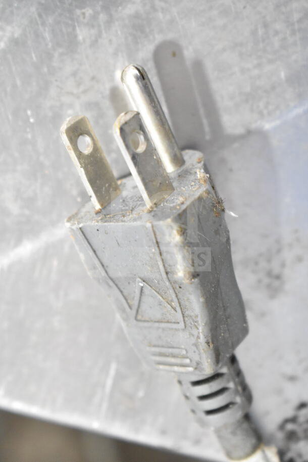 Close-up of a power plug from a SureShot Countertop Sugar Dispenser, 120 volts, 1 phase, showing wear and some residue.