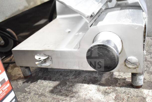 Commercial countertop meat slicer with blade sharpener, 115 volts, 1 phase. Visible wear, sturdy metal construction.