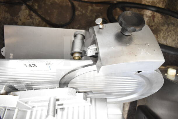 Commercial countertop meat slicer with blade sharpener, 115 volts, 1 phase, used condition. Includes auction tag 143.