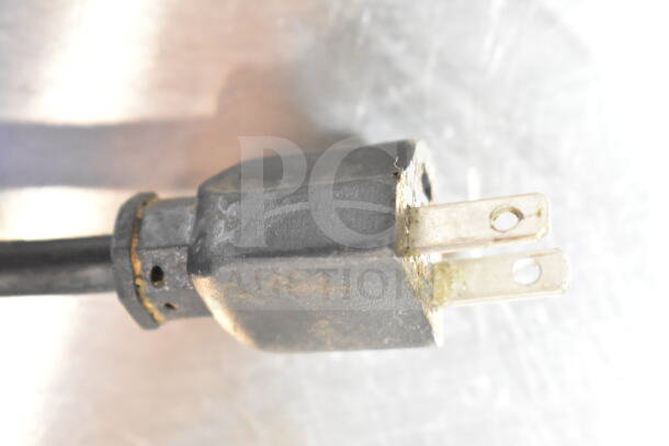 Close-up of a plug for a commercial countertop meat slicer, showing slight wear. 115 volts, 1 phase compatible.