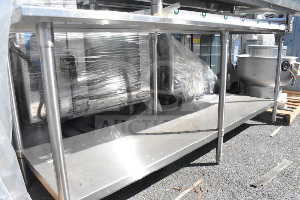 Commercial metal table with under shelf, used condition, suitable for kitchen or industrial use, sturdy construction.