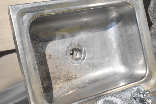Single bay wall mount sink, stainless steel, used condition with visible wear and residue in basin.