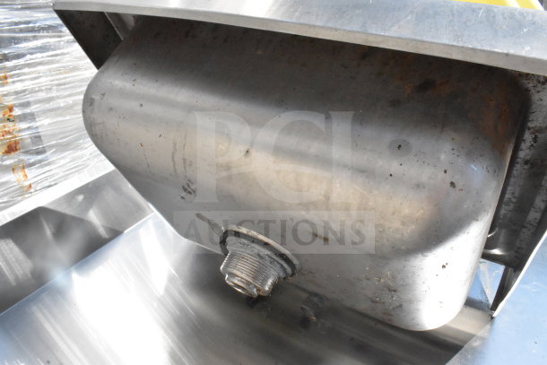 Single bay wall mount sink, stainless steel, visible wear and minor rust, industrial drainage fitting.