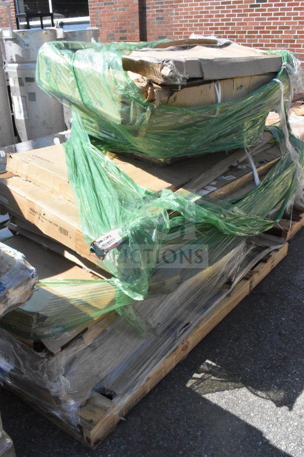 14 brand new scratch and dent items, including a table, on a pallet. Items are wrapped in green plastic and cardboard.