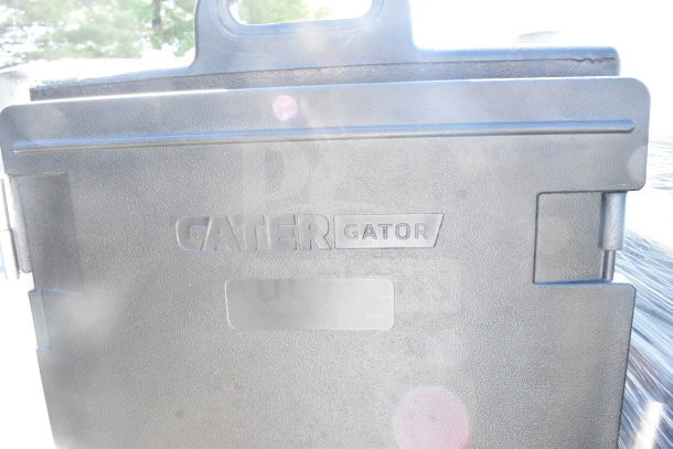 CaterGator black insulated food pan carrier, brand logo visible, scratch and dent condition. Includes dolly, 300 lb. capacity.