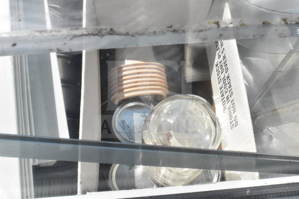 Master-Bilt commercial ice cream dipping cabinet interior with lids, cups, and storage dividers visible.