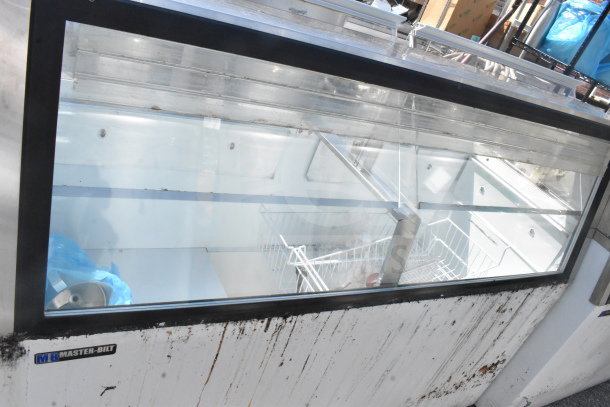 Master-Bilt commercial ice cream dipping cabinet with glass display, visible interior shelving, and exterior wear.