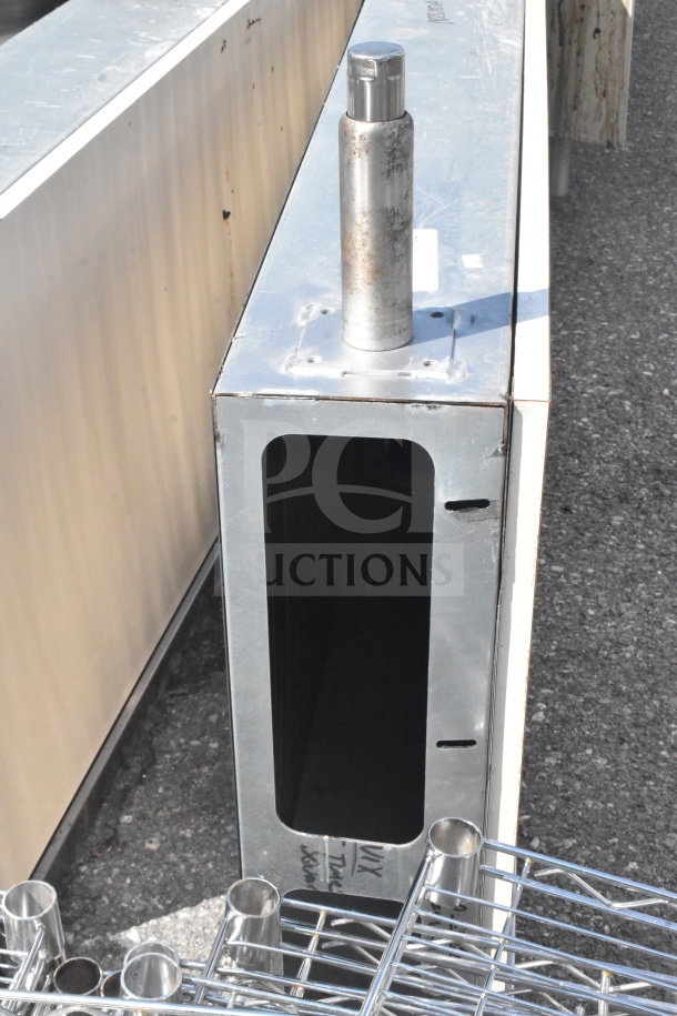 Metal frame with cylindrical holders and open slot; slight rust visible. Bid for two units to double your purchase.