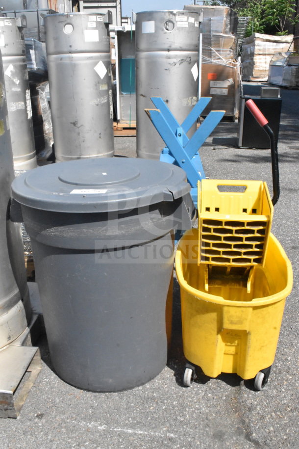 Gray trash can with lid and yellow mop bucket with wringer. Outdoor setting, items appear used. No visible markings.