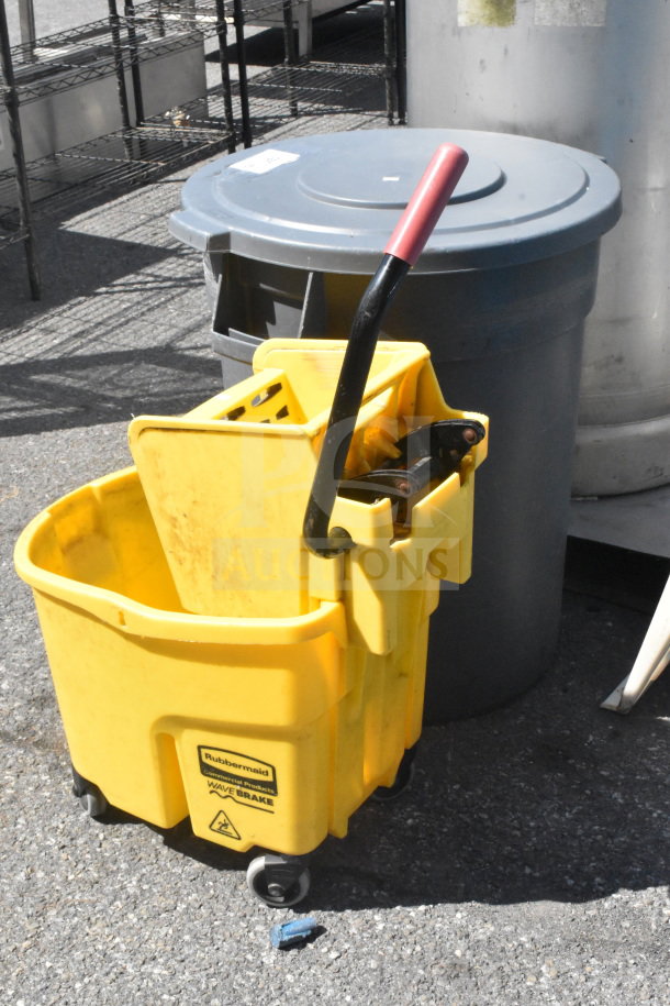 Yellow Rubbermaid WaveBrake mop bucket with wringer, wheels, and black handle next to a gray trash can with lid; used condition.
