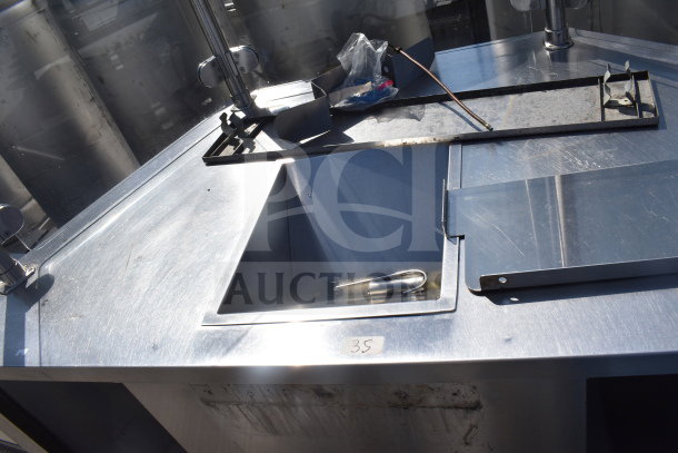 Counter with bay and sneeze guard in stainless steel, featuring compartments and tray. Some wear visible. Tag marked "35".