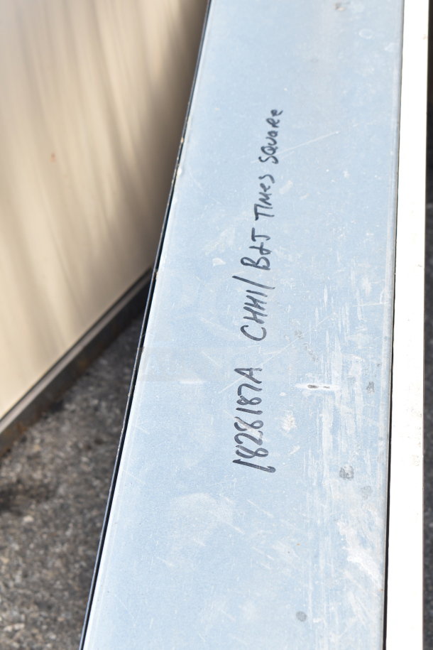 Two metal units with handwritten markings, "CH11 B&T Times Square" and "1826187A," indicating manufacturing details.