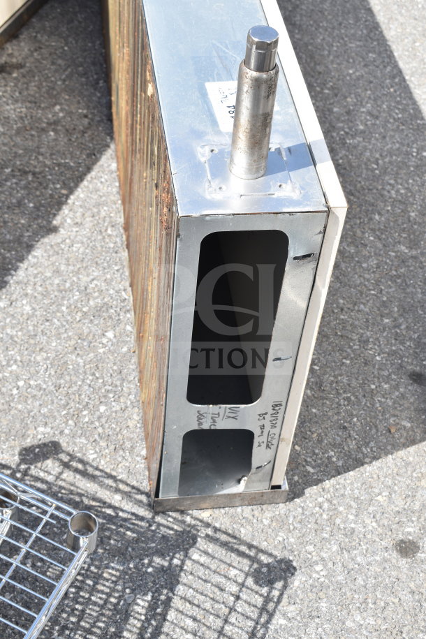 Two metal units with open slots, cylindrical post, and visible surface rust. Includes handwritten label with specifications.