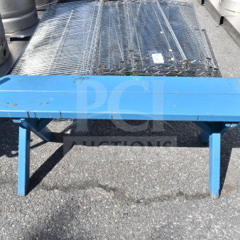 Blue wooden bench with signs of wear, visible scratches. Simple, sturdy construction. Ideal for outdoor use.