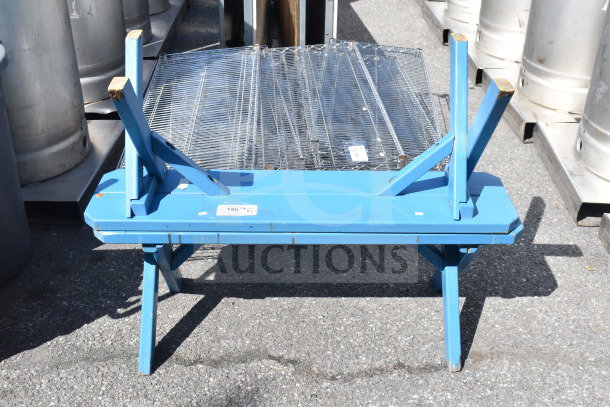Blue bench with foldable legs, metal frame on top, tags visible, sturdy design, for auction at 2 times your bid.