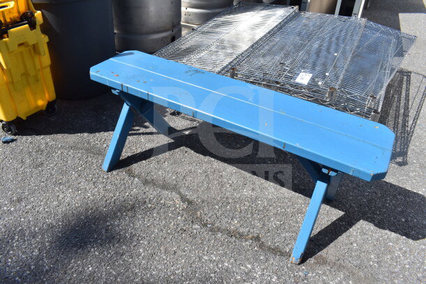 Blue wooden bench with simple design and visible wear, suitable for outdoor use. Auction item offering two benches for bid.