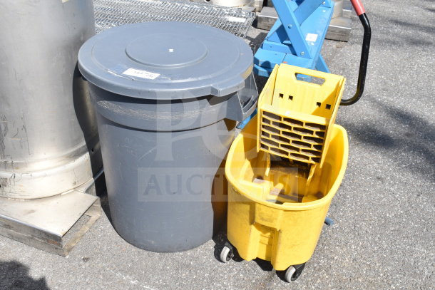 Gray trash can with lid and yellow mop bucket on wheels. Both show signs of wear. Label on trash can reads "107 OSHA."