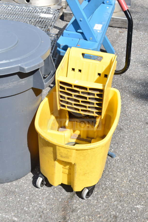 Yellow mop bucket with wringer and gray trash can on wheels, used condition.