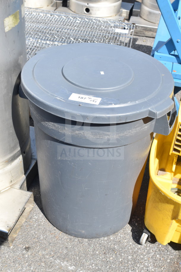 Gray trash can with lid and yellow mop bucket. Scratches visible. “Carlisle” label on trash can. Includes auction tag.