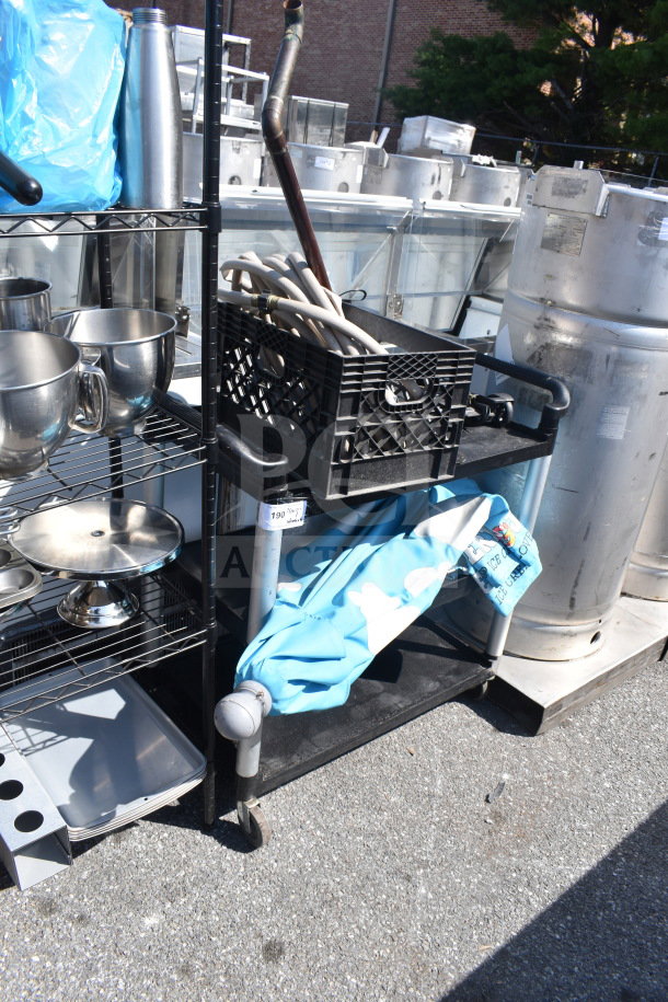 Black poly 2-tier cart with contents, including hoses and an umbrella, on commercial casters. Auction tag visible.