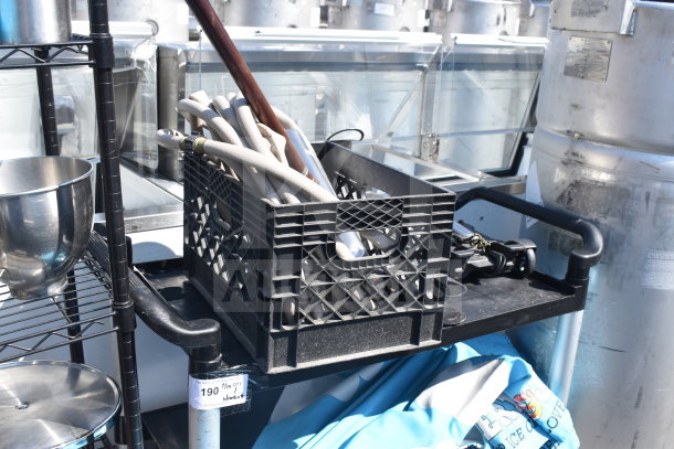 Black poly 2-tier cart with industrial casters, loaded with various contents including hoses and tools, in good condition.
