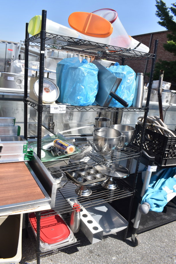Black 5-tier wire shelving unit filled with kitchen items including containers and stainless steel bowls. Buyer must dismantle.