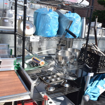 Black 5-tier wire shelving unit filled with kitchen items including containers and stainless steel bowls. Buyer must dismantle.