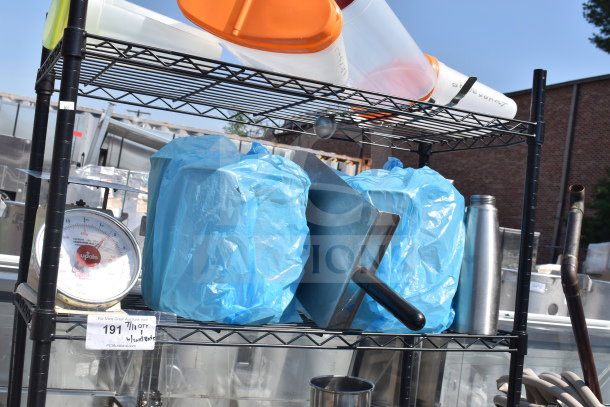 Black 5-tier wire shelving unit with assorted contents, including wrapped items and containers. Buyer must dismantle.