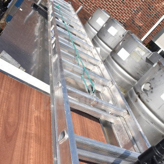 Werner 24' flat ladder, 225 lb capacity, aluminum, good condition, visible labels, green safety foot caps.
